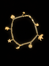 14k gold charm bracelet laid flat showing all 8 charms including elephant, star, sun and heart — True Smith Jewelers